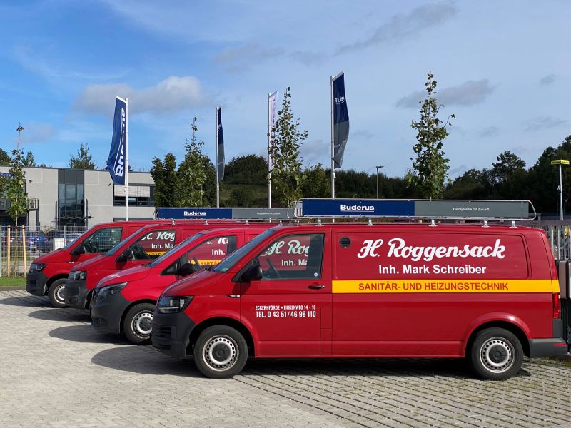 Fünf rote Transporter von H. Roggensack mit Aufschrift 'Sanitär- und Heizungstechnik' geparkt auf einem Firmengelände